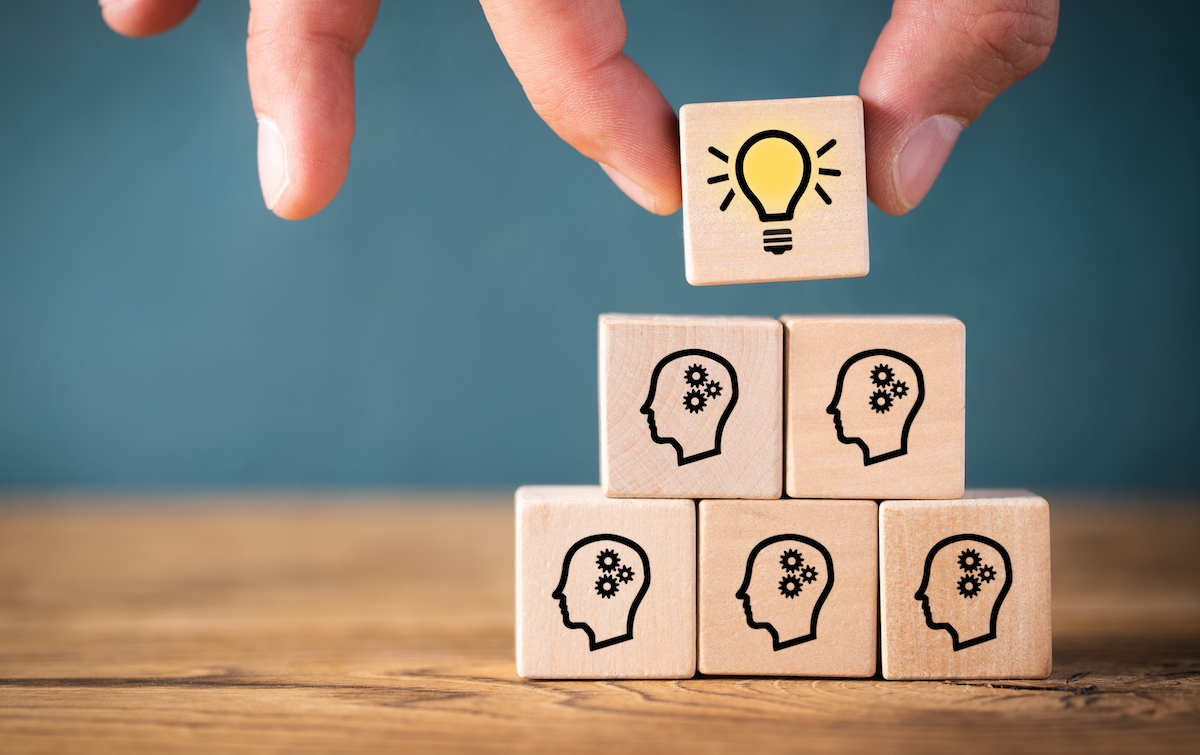 many people together having an idea symbolized by icons on cubes on wooden background